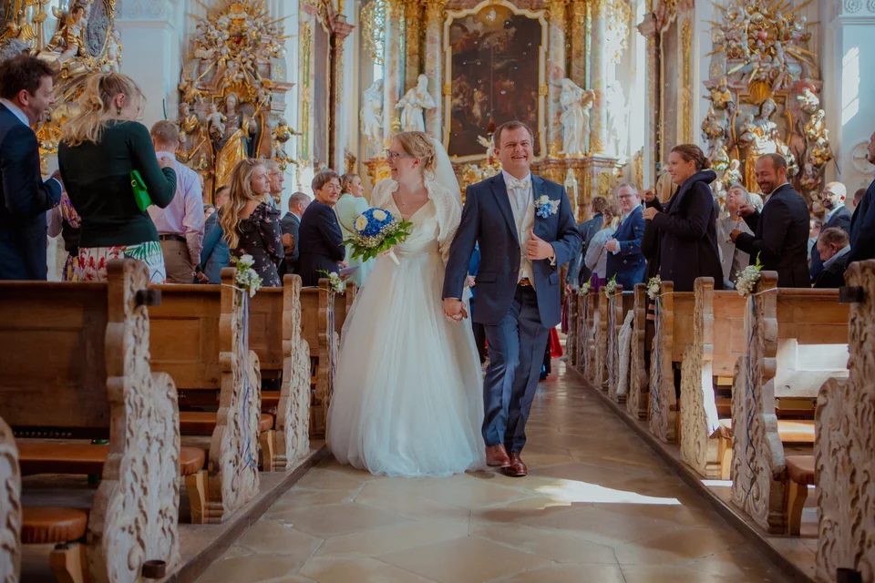 Brautpaar beim Auszug nach der kirchlichen Trauung in der Klosterkirche Kloster Holzen – emotionale Hochzeitsmomente in barocker Kirche, fotografiert von Hochzeitsfotograf René Cerny aus Augsburg