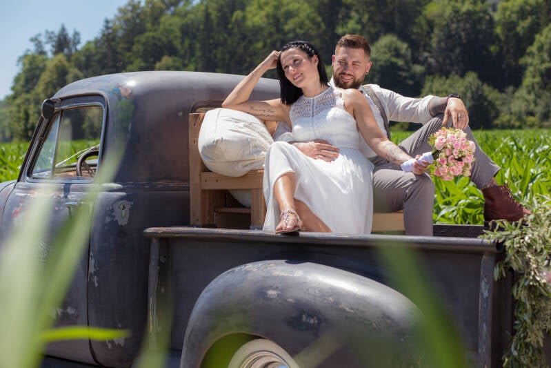 Brautpaar auf einem Vintage-Pickup im Feld