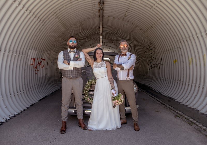 Brautpaar mit Trauzeuge am Vintage-Pickup im Tunnel